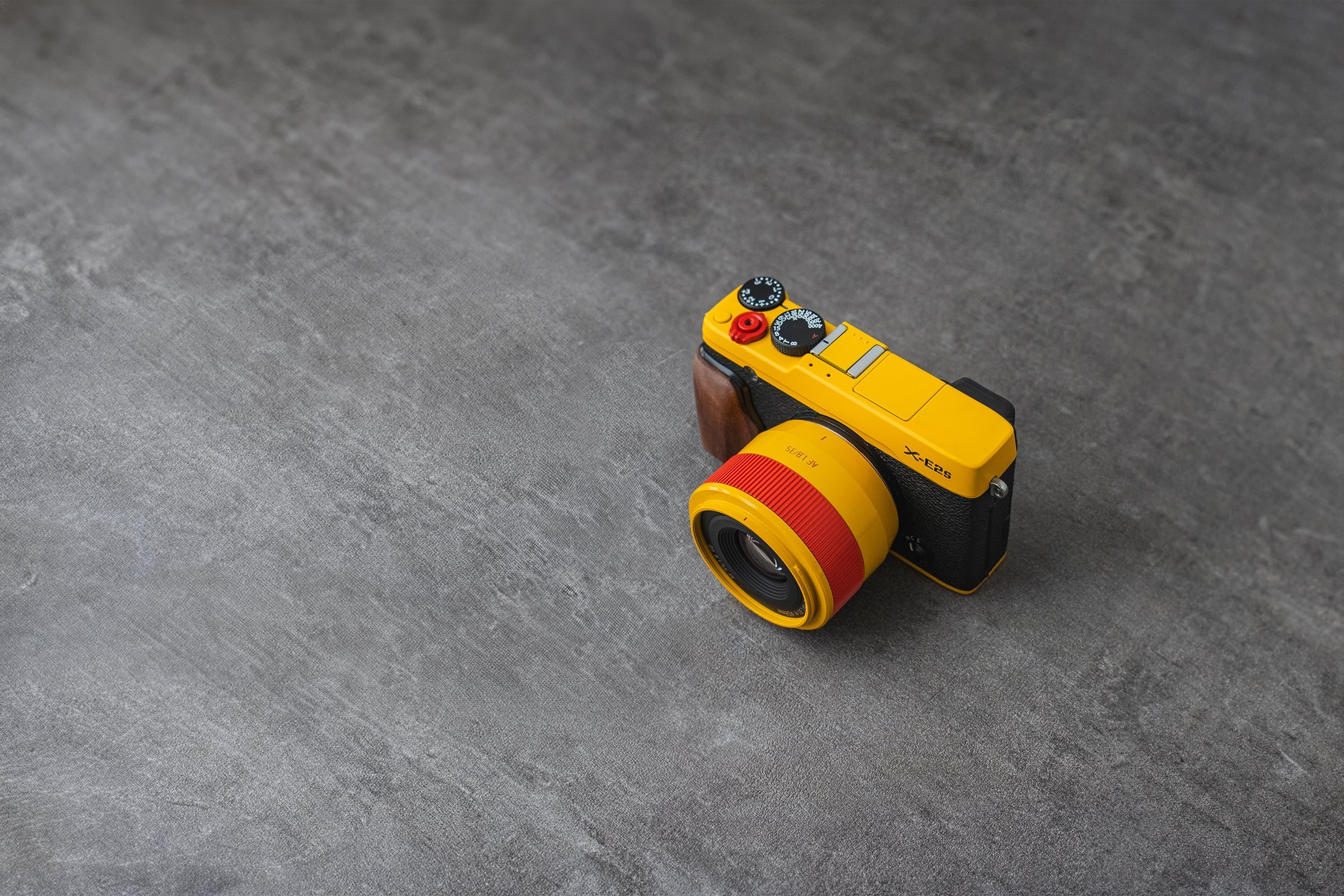 Yellow and red fuji camera on a gray surface